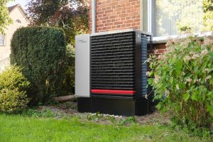 Wärmepumpe im Garten eines Hauses